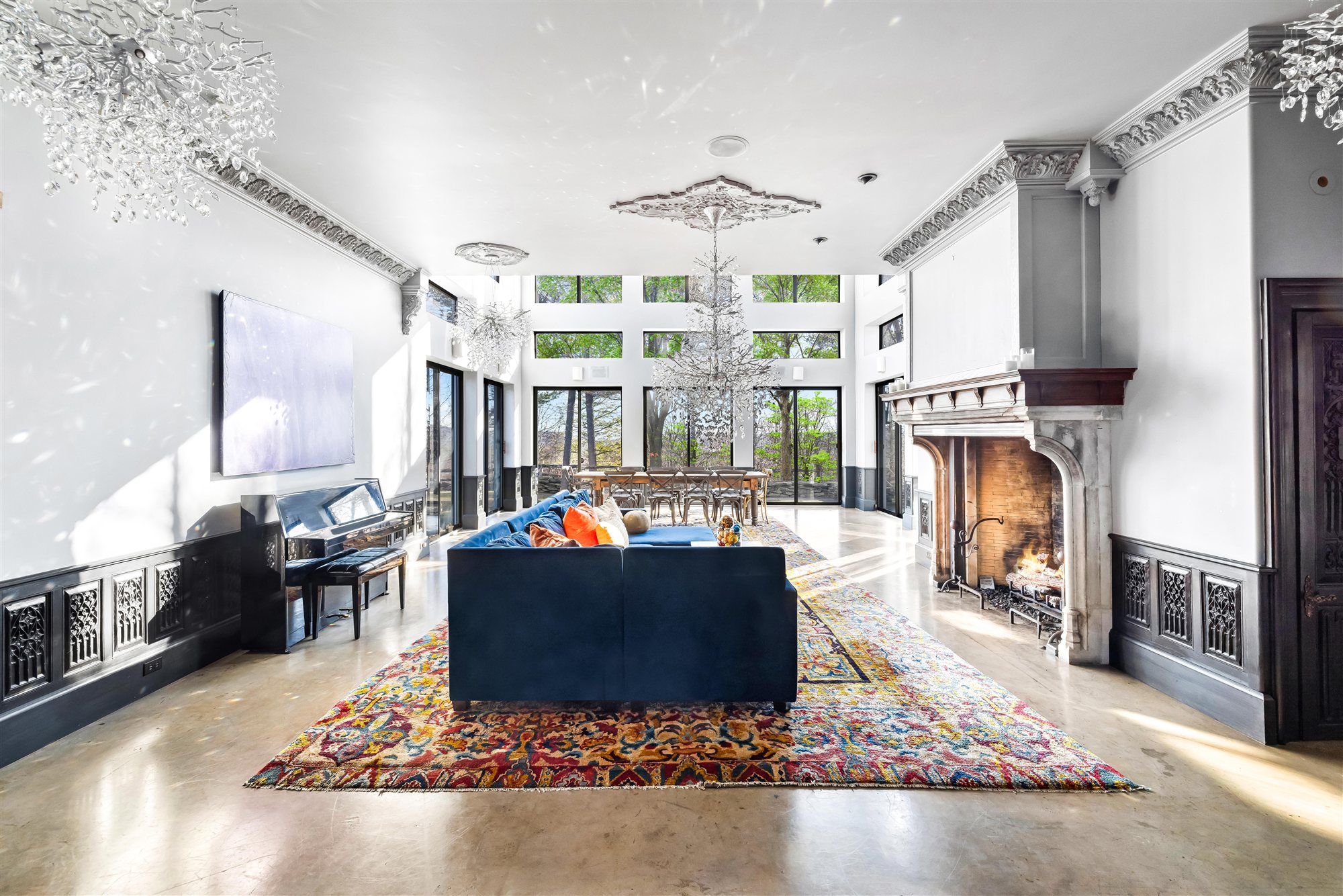 Piano, crystal chandeliers, and two-story windows