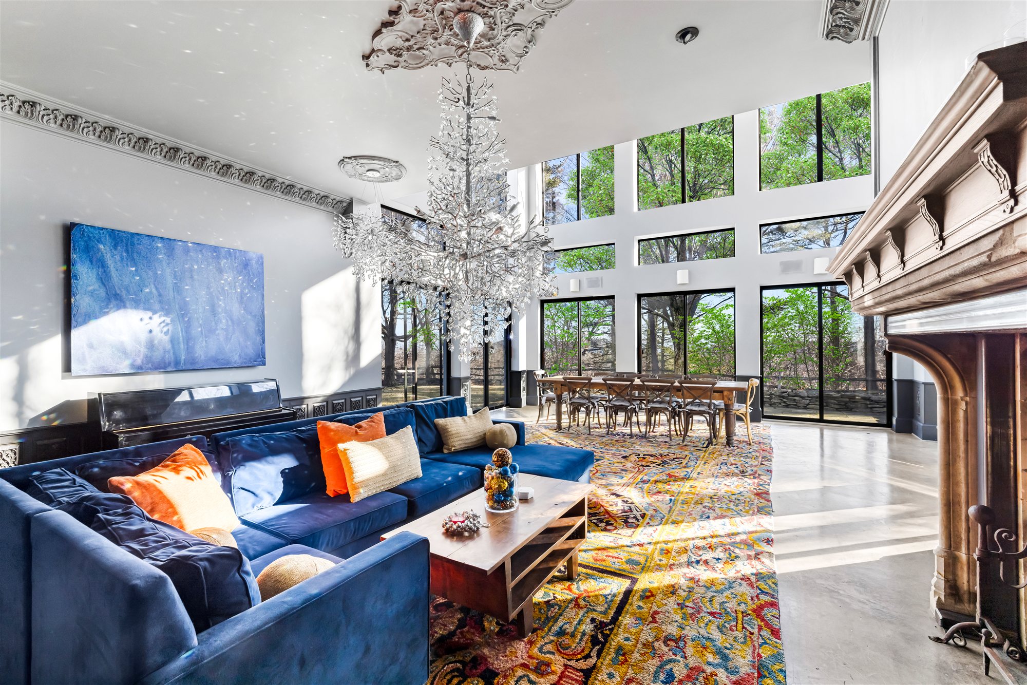 Blue velvet sectional beneath the branch chandelier