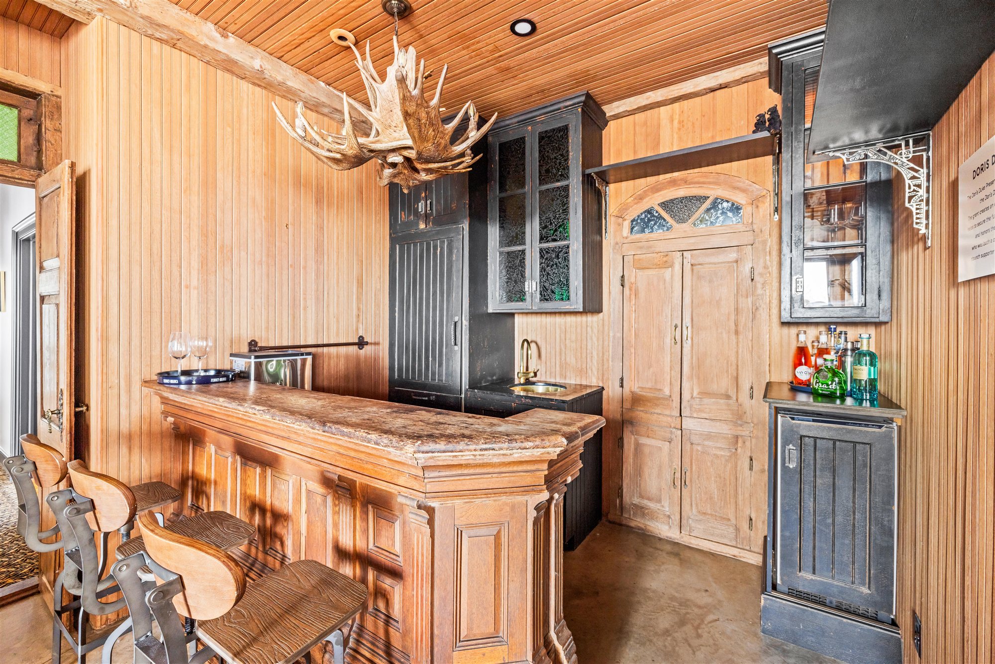 The bar — carved wood and an antler chandelier