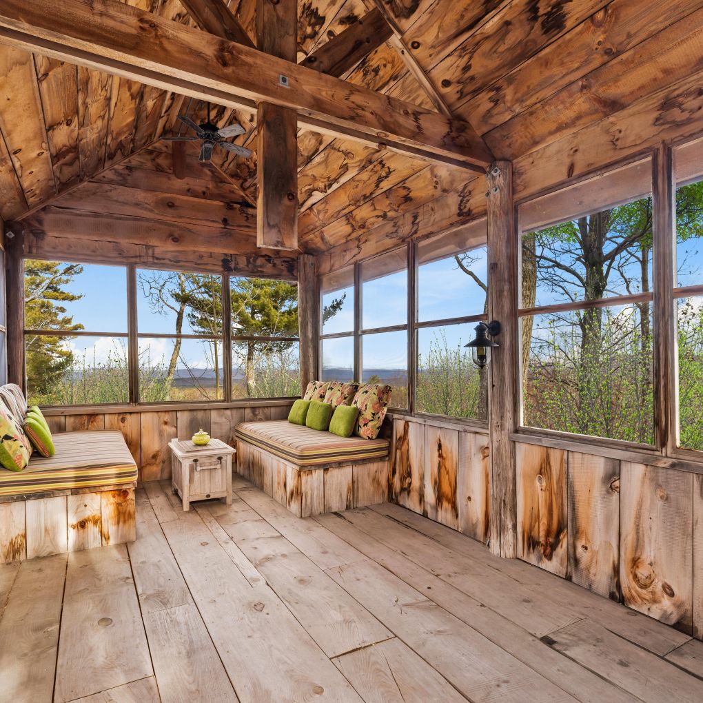 Screened treehouse interior with daybeds and Catskill views